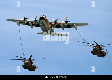 Israeli Air force Hercules C-130 transport plane refuelling two Sikorsky CH 53 helicopters in flight Stock Photo