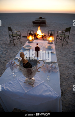 Botswana, Makgadikgadi. A romantic dinner for two is set up at sunset on the empty Makgadikgadi saltpans. Stock Photo