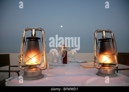 Botswana, Makgadikgadi. A romantic dinner for two is set up at sunset on the empty Makgadikgadi saltpans. Stock Photo
