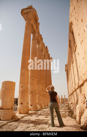 Syria, Palmyra. A tourist stands beneath the towering columns of the Bel Temple.(MR) Stock Photo