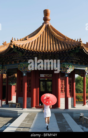 China, Beijing, Ethnic Minorities Park, a girl with parasol at a pavilion Stock Photo