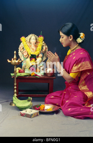 RHS 60955 : Ganesh ganpati festival ; Maharashtrian lady praying in front of elephant headed god idol MR#138 Stock Photo