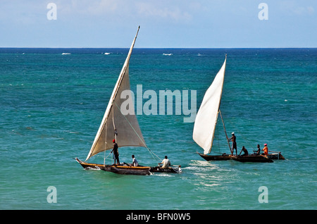 Kenya, Mombasa. Two outrigger canoes sail in the clear waters of the Indian Ocean, off Diani Beach. Stock Photo