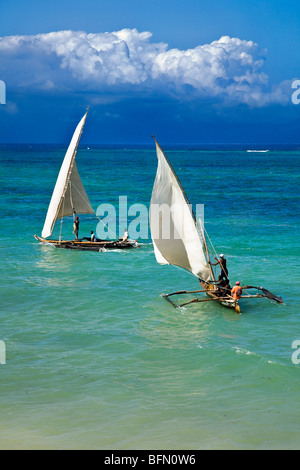 Kenya, Mombasa. Two outrigger canoes sail in the clear waters of the Indian Ocean, off Diani Beach. Stock Photo