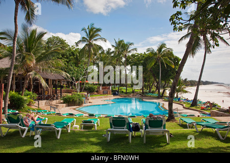 Kenya, Mombasa. The swimming pool of Baobab Resort with the white sands of Diani Beach in the background. Stock Photo