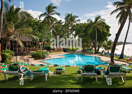 Kenya, Mombasa. The swimming pool of Baobab Resort with the white sands of Diani Beach in the background. Stock Photo