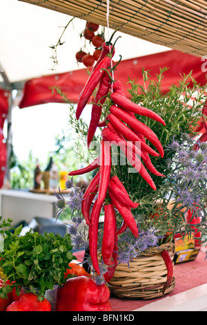 Drying hot chili peppers hanging on a string outside Stock Photo