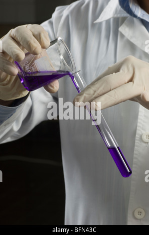 Scientist mixing solutions in test tubes Stock Photo