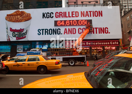 Workers put the finishing touches on a billboard for Kentucky Fried Chicken's new grilled chicken product in NY in Times Square Stock Photo