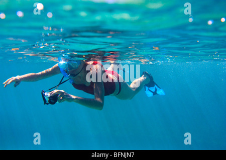 Young woman in snorkeling gear taking picture underwater Stock Photo