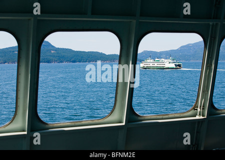 A Washington State ferry seen through the windows of another stste ferry in the San Juan Islands, Washington, USA. Stock Photo