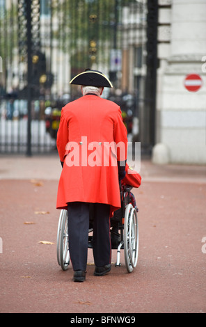 A Chelsea pensioner pushing a disabled war veteran in a wheelchair. Stock Photo
