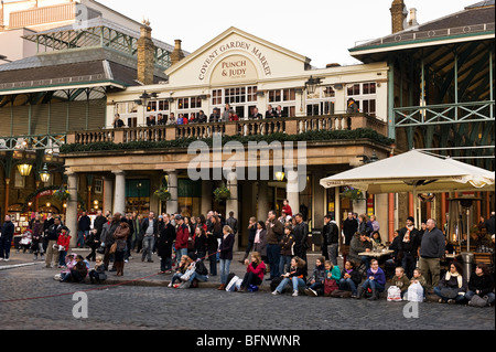 Crowds of people and tourists in front of the Punch and Judy pub Covent Garden watching the performance of a street entertainer. Stock Photo