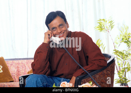 Indian senior man talking on telephone sitting in house ;  MR#448 Stock Photo