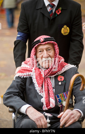 A disabled war veteran in Arab headgear in a wheelchair at the Remembrance Day Parade London UK Stock Photo