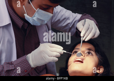Dentist wearing mask seeing teeth of patient ; MR#395 Stock Photo