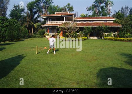 Boy playing cricket ; bungalow with garden ; Nere ; Panvel ; Bombay ; Mumbai ; Maharashtra ; India ; Asia ; PR# Stock Photo