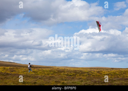 12 year old boy flying a power kite in high winds on moorland east of Syre, Sutherland, Highland, Scotland Stock Photo