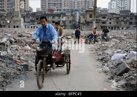 People through ruins of dilapidated residential area in Yangpu district, Shanghai, China. 16-Oct-2009 Stock Photo