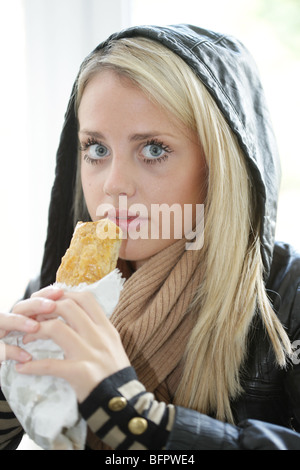 Teenage Girl Eating Saugage Roll. Model Released Stock Photo