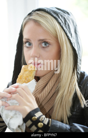 Teenage Girl Eating Saugage Roll. Model Released Stock Photo