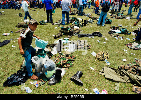 A young Colombian boy searching for the army gear after the demobilization ceremony of the AUC paramilitary forces, Colombia. Stock Photo