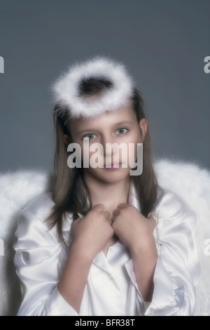 studio portrait of an eleven years old girl dressed as angel Stock Photo