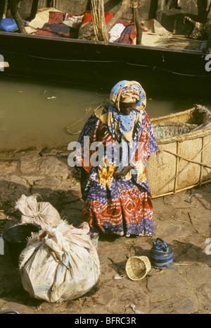 Bozo woman prepares her baggage before boarding a pinasse the local river taxis of the Niger River Stock Photo