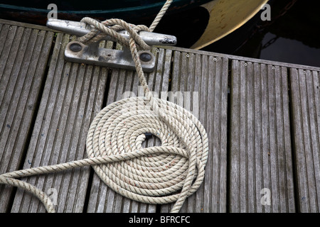 Coiled rope on quayside Stock Photo