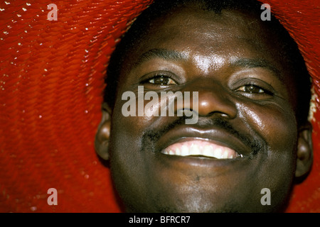 Subsistence farmer wearing red straw hat smiling Stock Photo