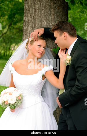 Three quarter body portrait of happy young couple looking lovingly at each other in forest. Stock Photo