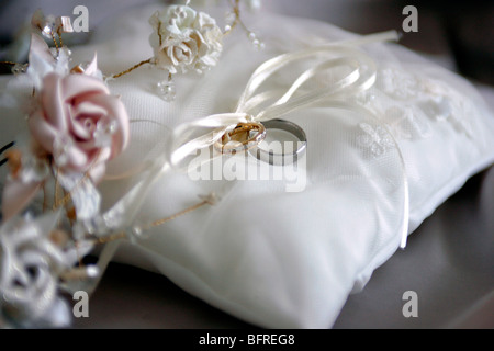 Closeup of bride and groom wedding rings on white cushion. Stock Photo