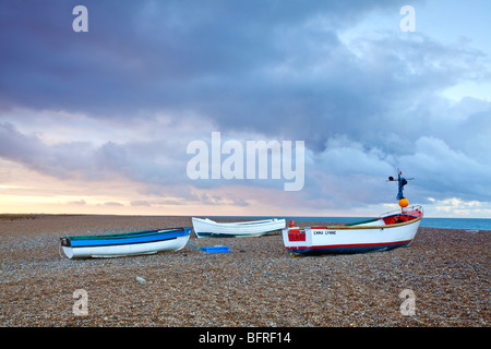 Stormy sunset & fishing boats at Cley beach on the North Norfolk Coast Stock Photo