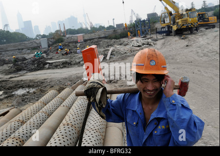 Chinese worker using his moblie phone in a construction site in Shanghai, China. 16-Oct-2009 Stock Photo
