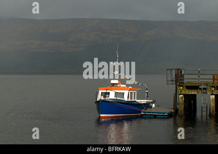 Small blue boat moored at Luss Pier on Loch Lomond, Scotland Stock Photo