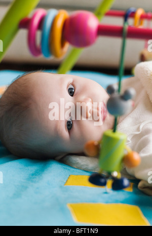 Baby Lying on Floor with Toys Stock Photo