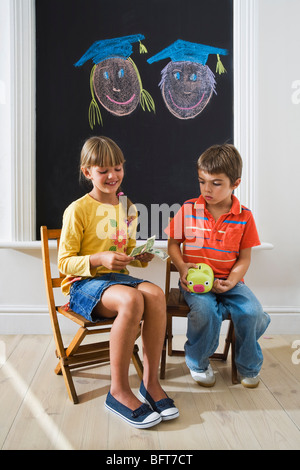 Boy and Girl Counting Money for College Fund Stock Photo