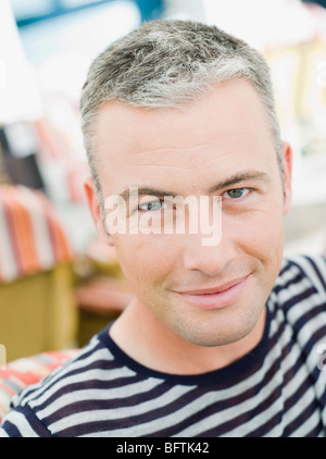 man sitting in a city cafe smiling Stock Photo