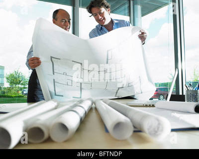 Architects looking at blue prints Stock Photo