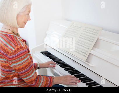 A senior female playing the piano Stock Photo