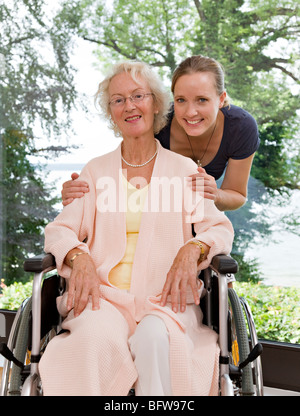 woman touching senior woman's shoulders Stock Photo
