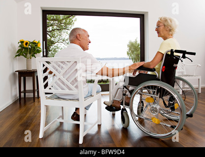 man touching woman in wheelchair Stock Photo