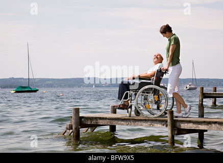 woman and senior man in wheelchair Stock Photo
