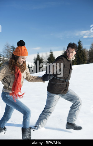 Couple running in winter scene Stock Photo