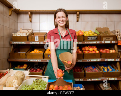 shopkeeper packing fruit in bag Stock Photo