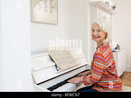 A senior female playing the piano Stock Photo