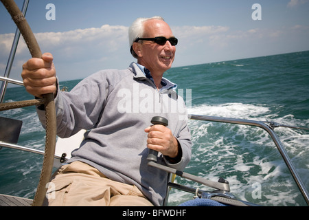 Mature man sailing yacht Stock Photo