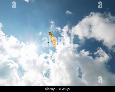 Senior paraglider in midair against sky Stock Photo