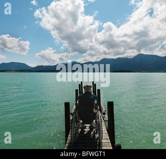 Senior man in wheelchair by lake Stock Photo