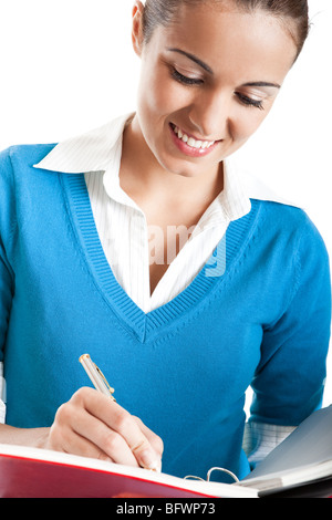 Beautiful female student writing something, isolated on white Stock Photo